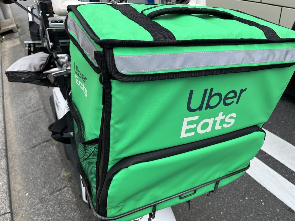 ウーバーイーツの緑色の公式配達バッグを原付の荷台に固定した外観。